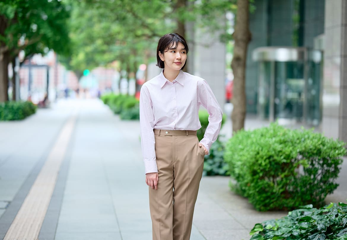 シャツはピンクにベージュのボーダーを選び、さりげない色合わせを