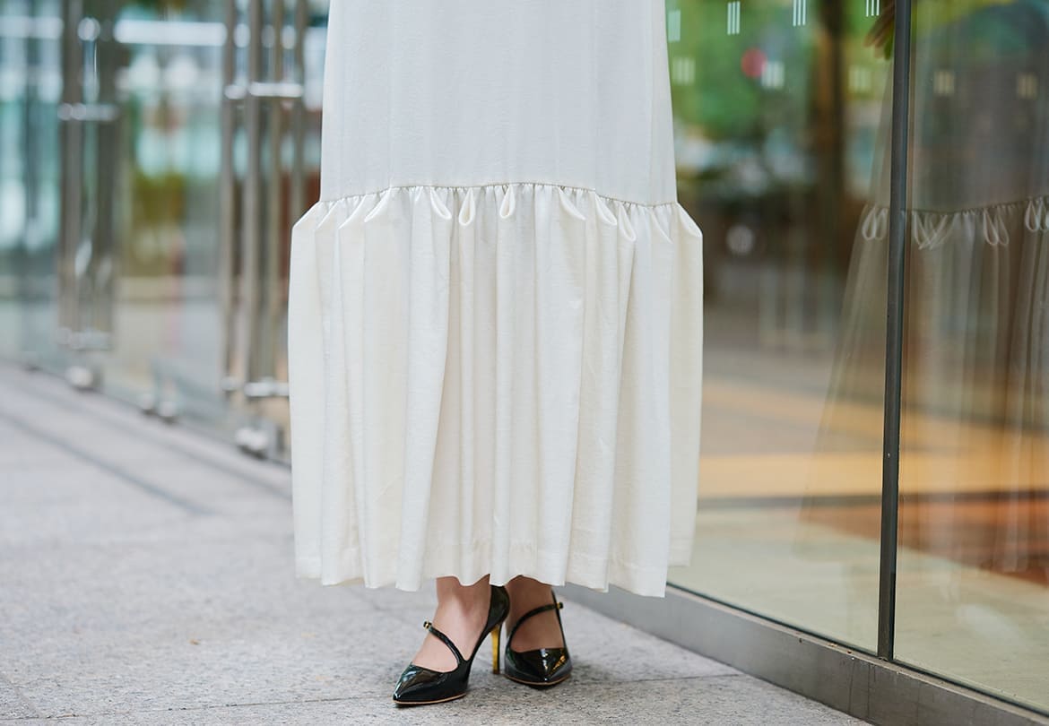 裾の切り替え部分に施されたユニークなタックがポイント