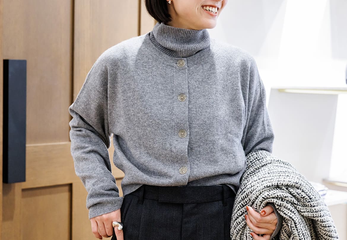 カシミヤ100％のニットを重ね着。大きくて丸いボタンがクールになりすぎない