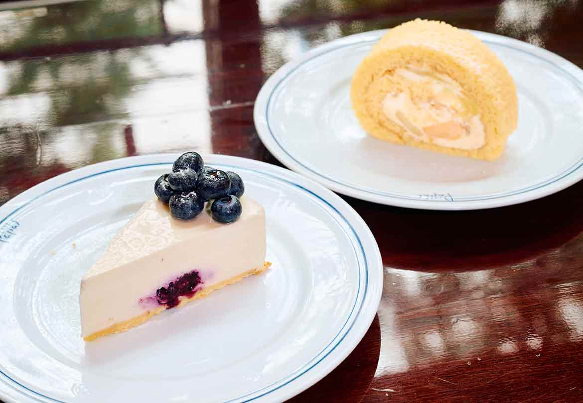 （手前）「ブルーベリーレアチーズケーキ」880円、（奥）「フルーツロールケーキ」880円