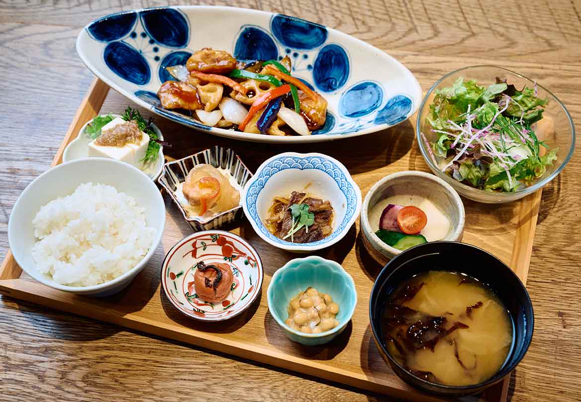 酢豚を中心に多彩な小鉢が並ぶ。味噌汁おかわり無料